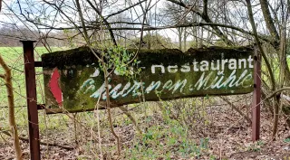 Verfallenes Hinweisschild zum Restaurant Schwanenmühle